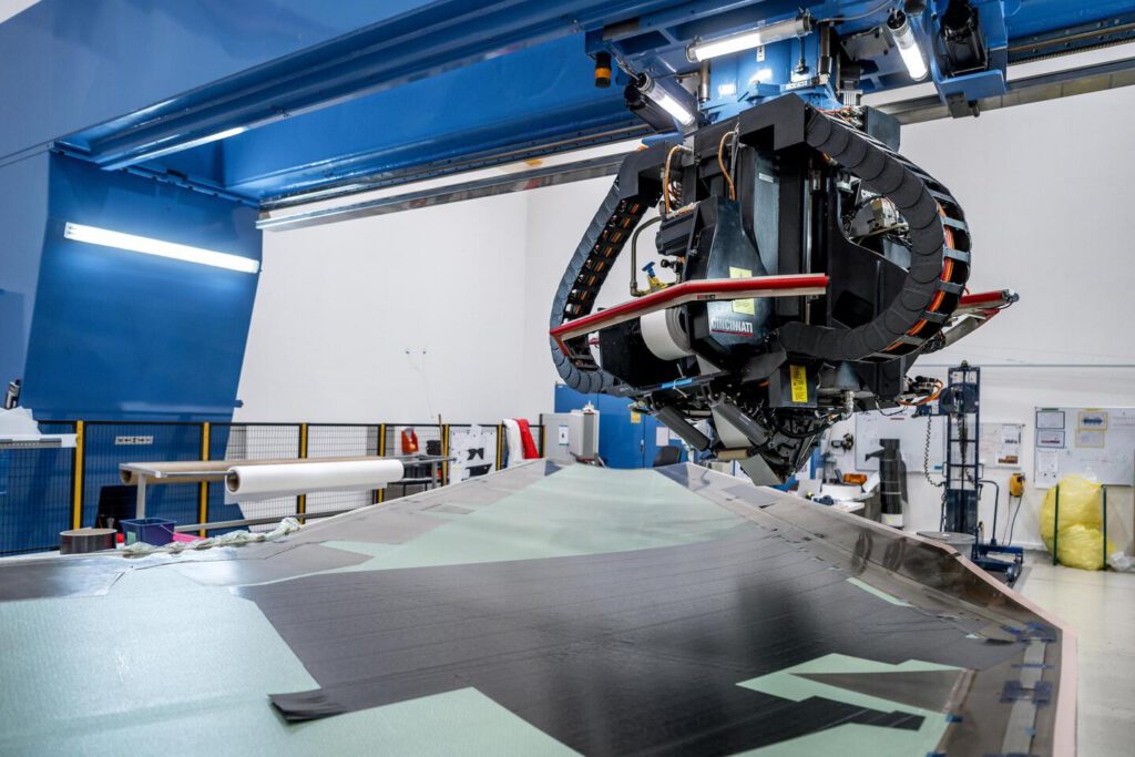 An automated fibre placement machine laying carbon plies over a tail-plane mould