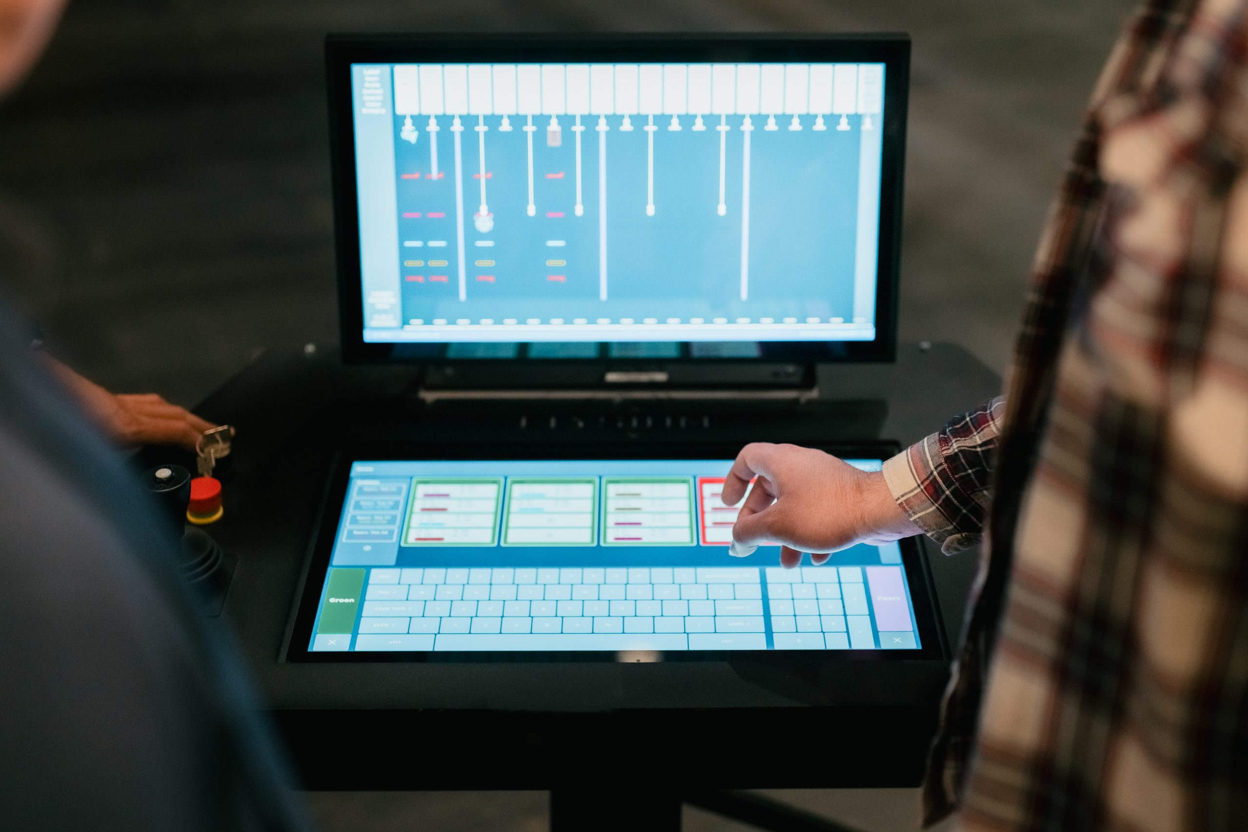 Touchscreen control panel with an emergency stop button, used to operate the stage rigging
